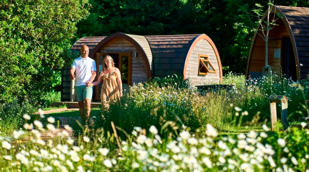 Older couple walking hand in hand away from Whitemead glamping pod